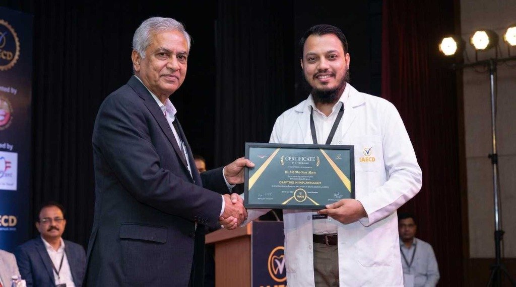 Dr. Shahbaz Alam receiving Grafting in Implantology certificate on stage